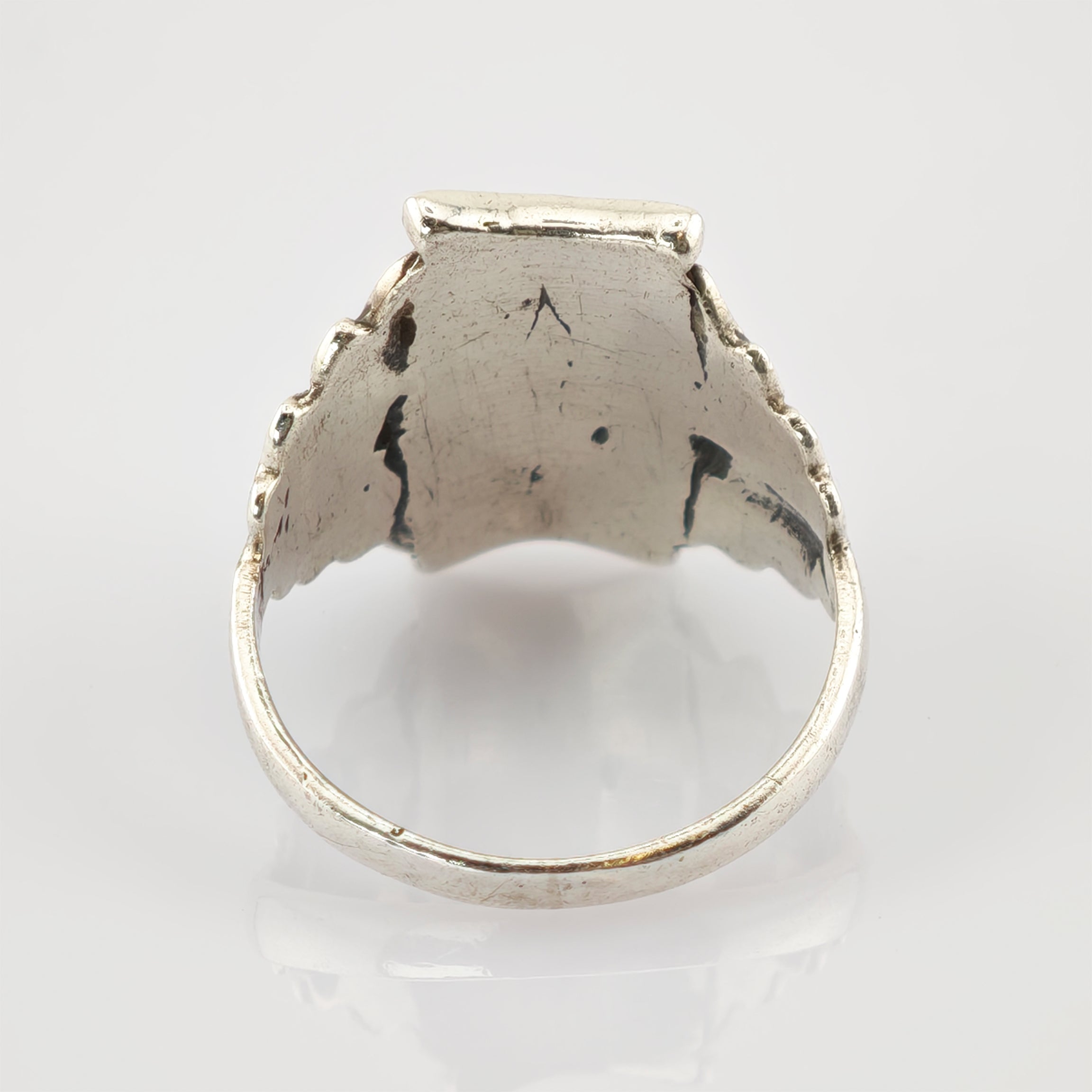 Abgenutzter Metallring mit glatter, abgerundeter Innenfläche und Kratzern.