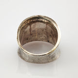 Nahaufnahme eines alten silbernen Rings mit breitem Band und sichtbarer Patina auf weißem Hintergrund