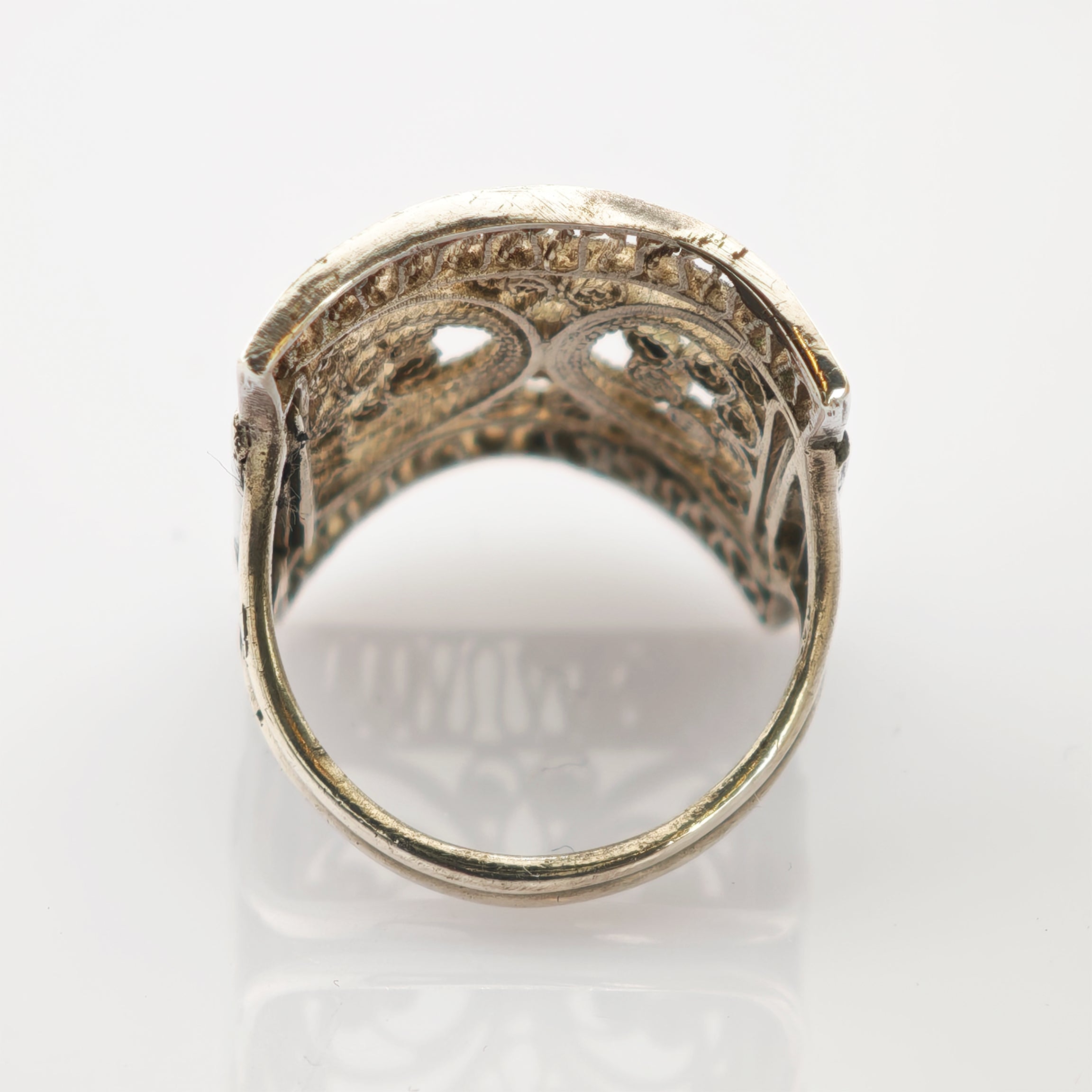 Antiker Goldring mit filigranem Schnittmuster und gewölbtem Oberteil in seitlicher Perspektive.