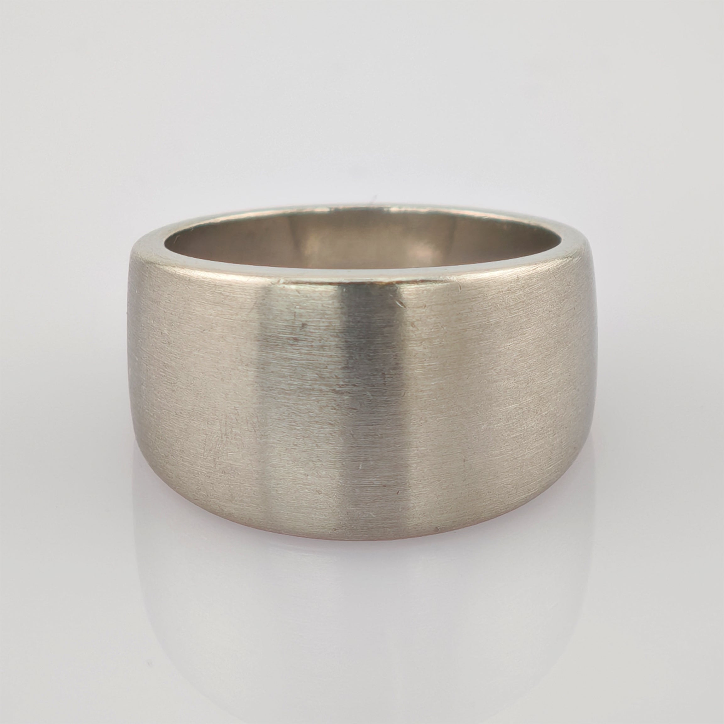 Breiter mattierter Ring aus Metall mit gebürsteter Oberfläche und abgerundeten Kanten.