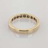 Einfacher goldfarbener Ring mit Gravur '10KT MEX 2H DE 14' auf der Innenseite, reflektierend auf heller Fläche.