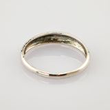 Einfacher silberner Ring mit leichten Anlaufspuren und kleinen Kratzern auf weißem reflektierendem Hintergrund.