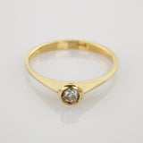 Eleganter Goldring mit rund geschliffenem Diamant in Fassettensitz auf weißem Hintergrund.