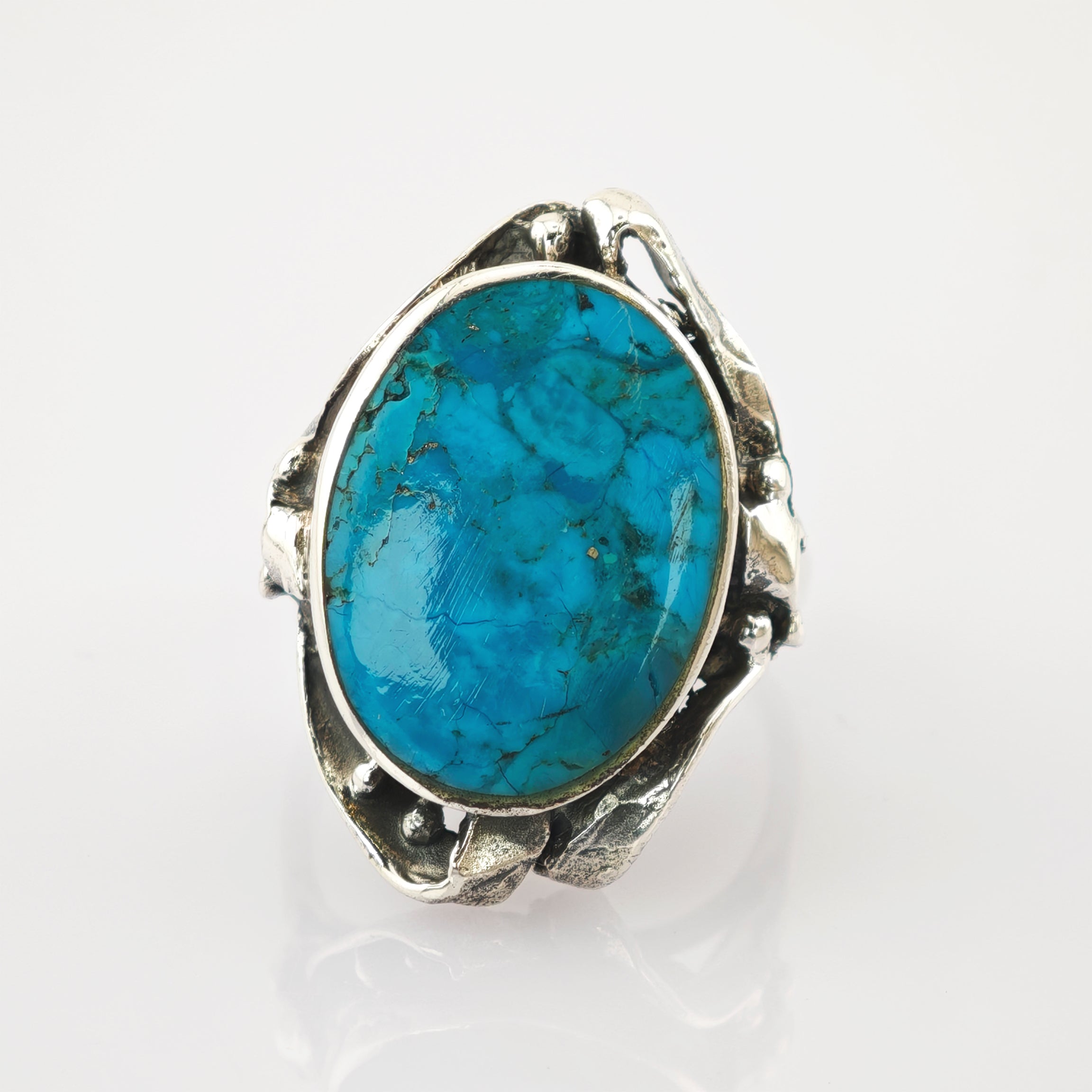 Eleganter Silberring mit ovalem Türkisstein und kunstvollen Details im Vintage-Stil.