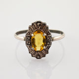 Eleganter Vintage-Silberring mit detaillierter Verzierung und ovalem gelben Edelstein.