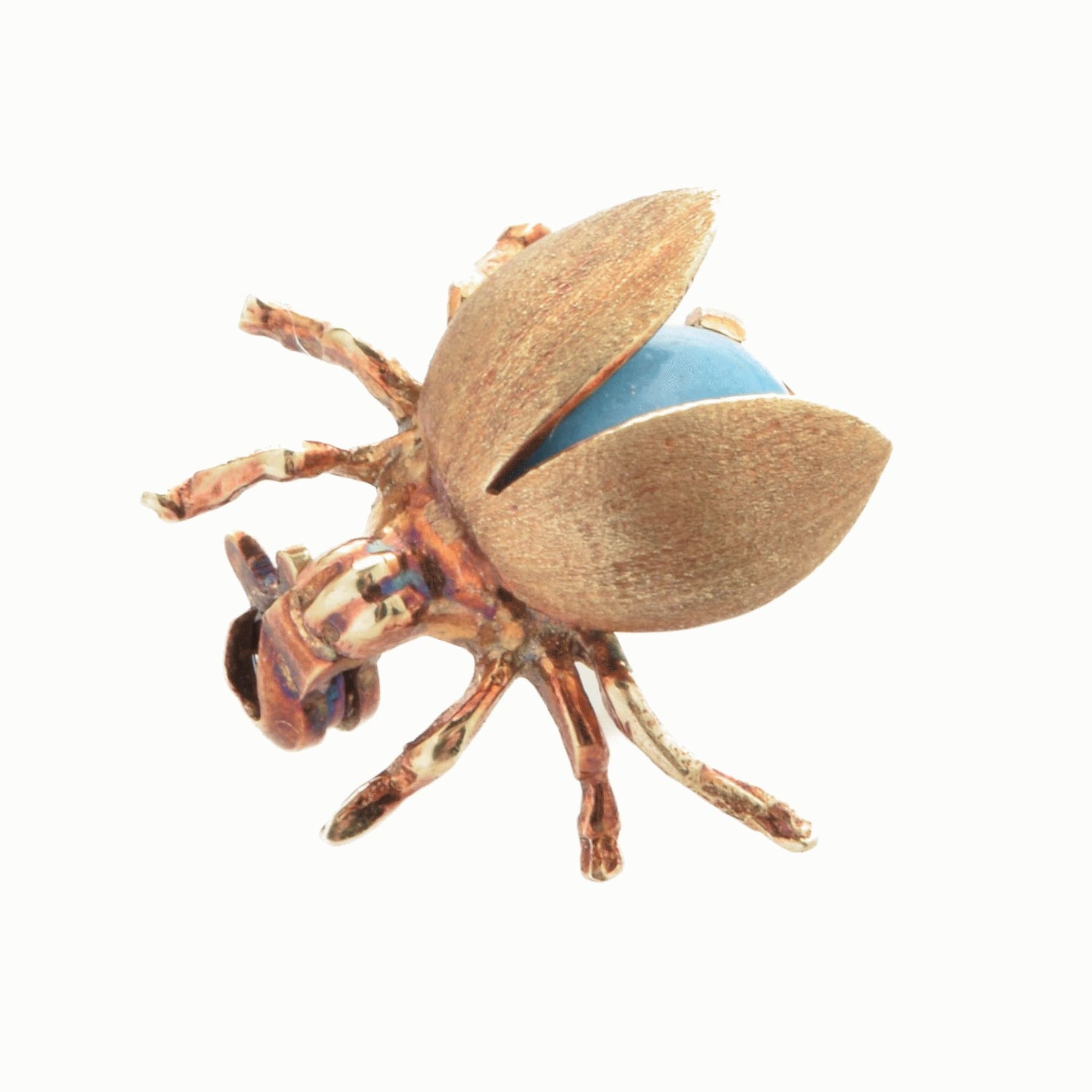 Fein gearbeitete bronzefarbene Käferskulptur mit blauem Kugelobjekt im Inneren vor weißem Hintergrund.