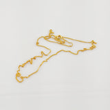 Fein gearbeitete Goldkette mit rundem Verschluss auf schlichtem weißem Hintergrund