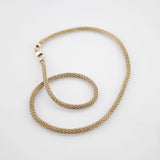 Feine Goldkette mit Diamantmuster und massivem Karabinerverschluss auf weißem Hintergrund.