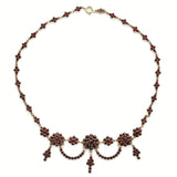 Feine Vintage-Halskette aus Gold mit blumenförmigem Cluster aus dunklen roten Steinen und hängenden Elementen