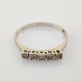 Feiner Ring mit fünf kleinen quadratischen Fassungen und funkelnden Steinen.