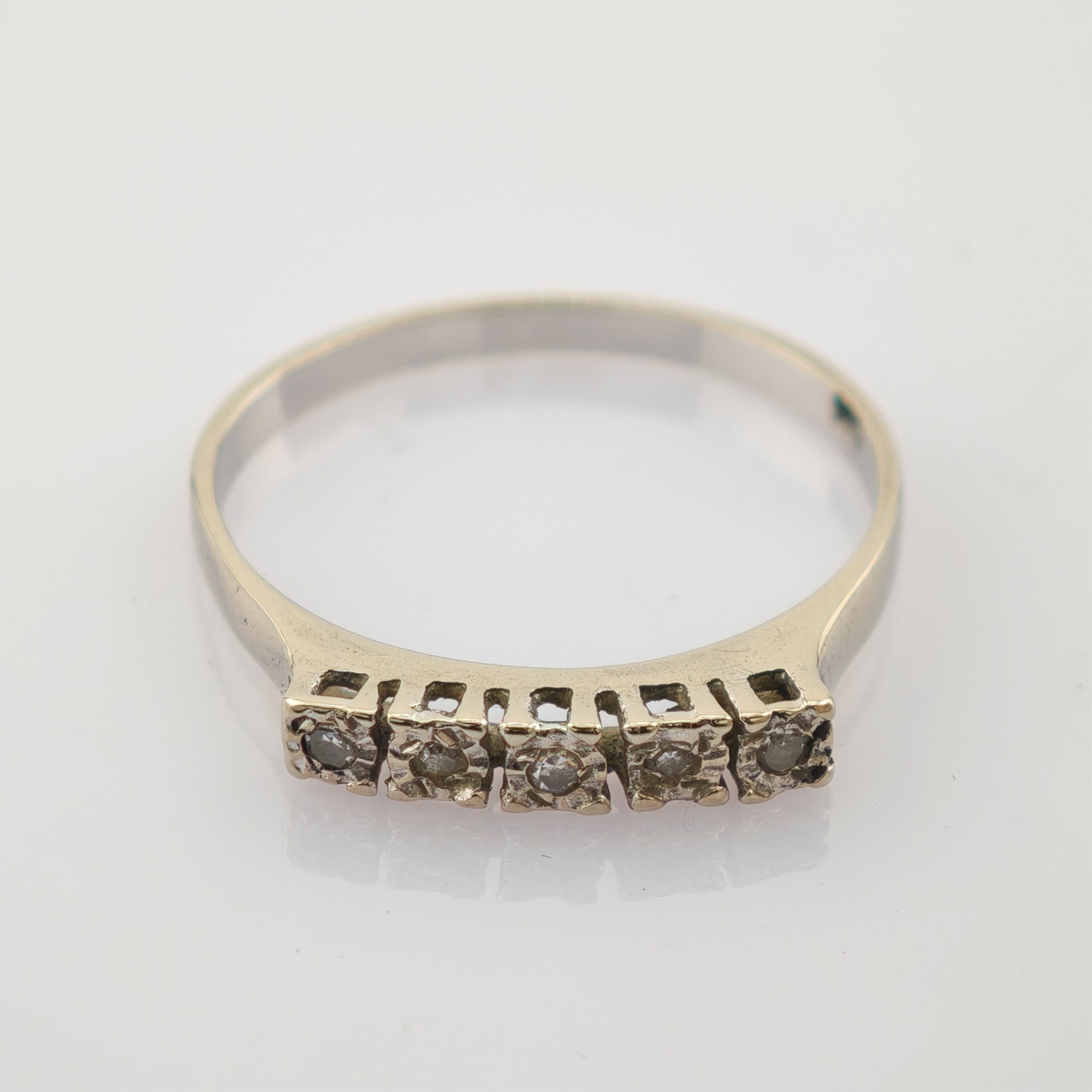 Feiner Ring mit fünf kleinen quadratischen Fassungen und funkelnden Steinen.