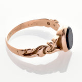 Feiner Vintage-Ring aus Gold mit kunstvollen Wirbelmustern und ovalem dunklem Stein in der Mitte.