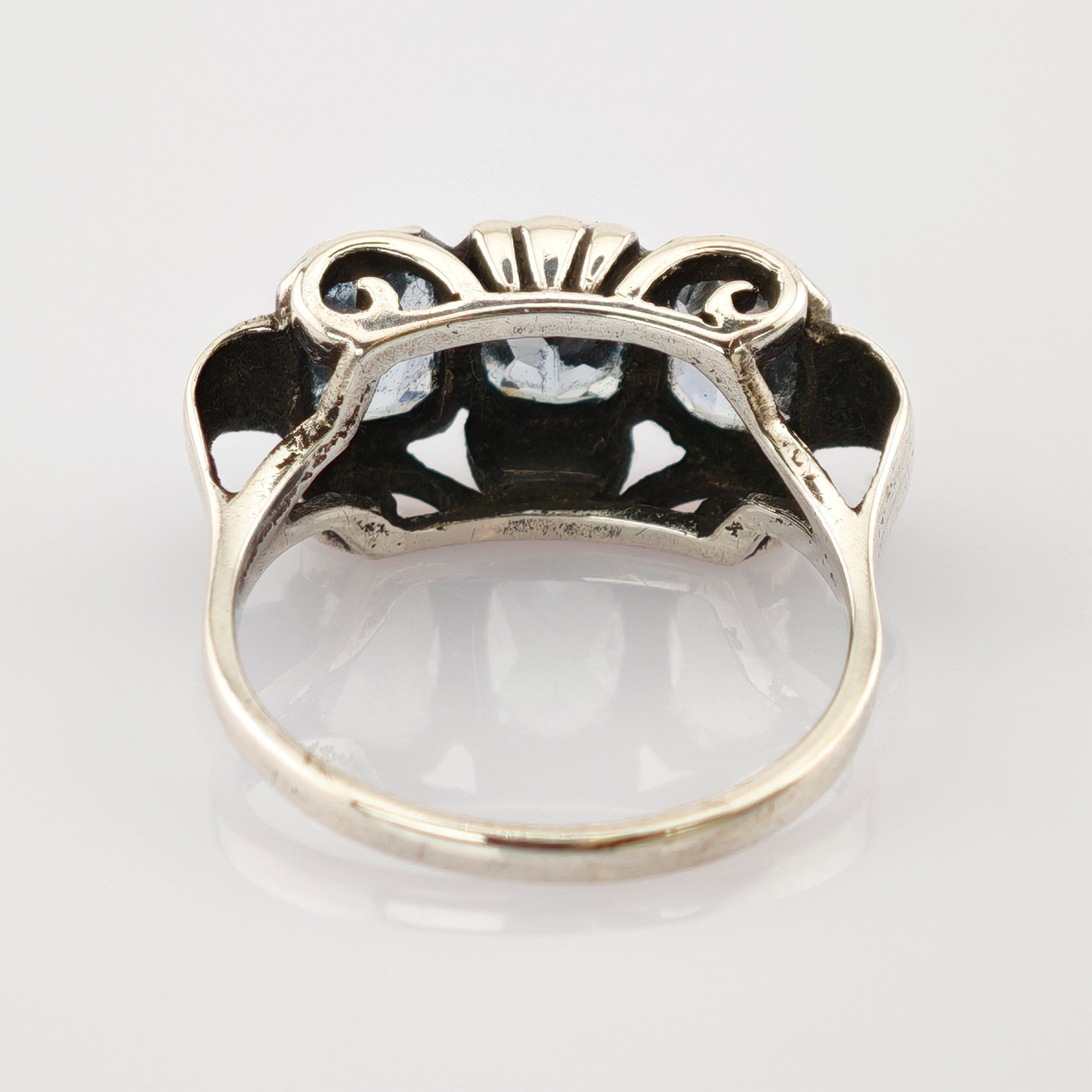 Detaillierter Blick auf die filigrane Silberringunterseite mit kunstvollen Metallarbeiten und Hohlmustern.