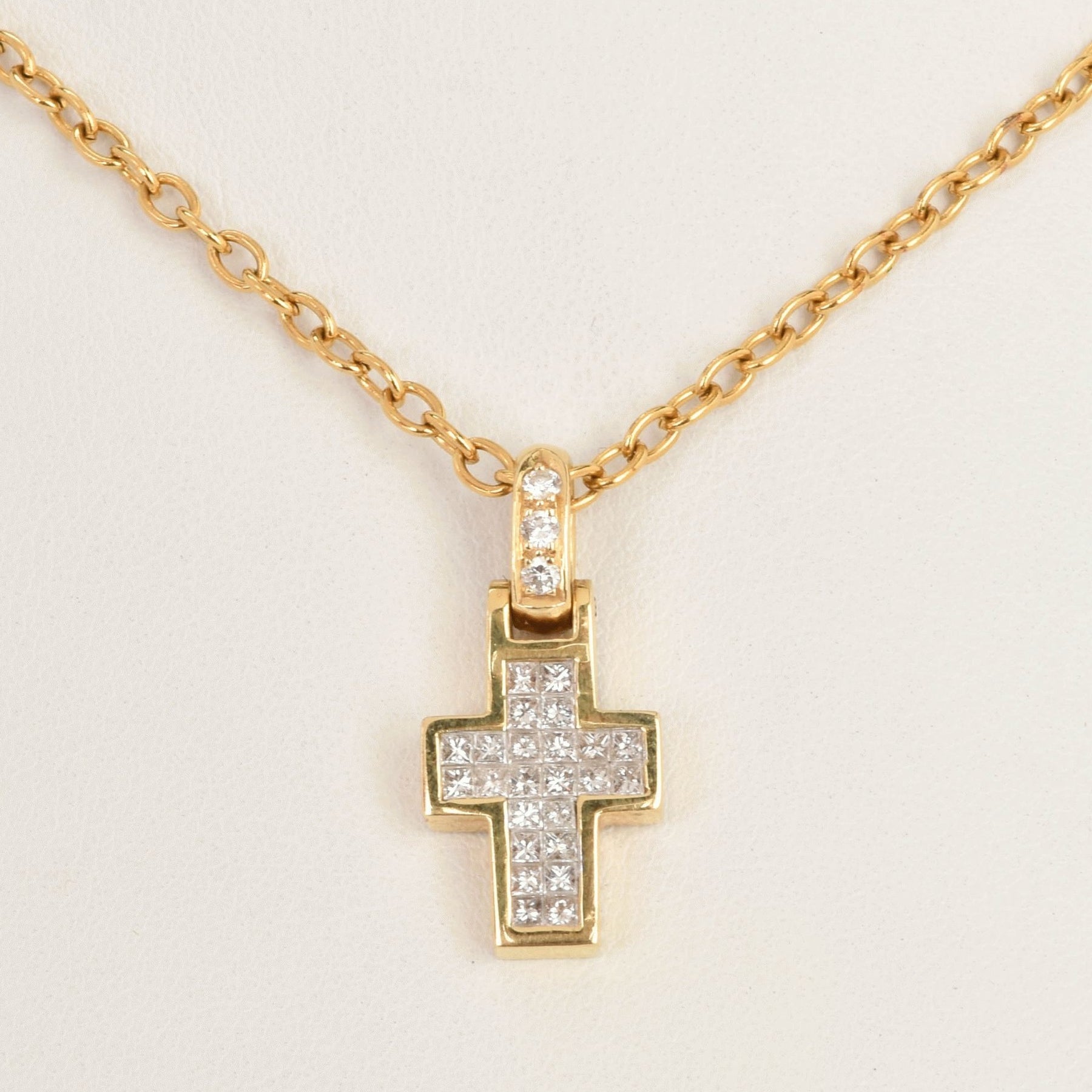 Goldene Kette mit Kreuzanhänger aus kleinen quadratischen Diamanten.