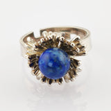 Goldener Ring mit rundem blauem Stein und blütenförmiger Fassung, Vintage-Schmuck.