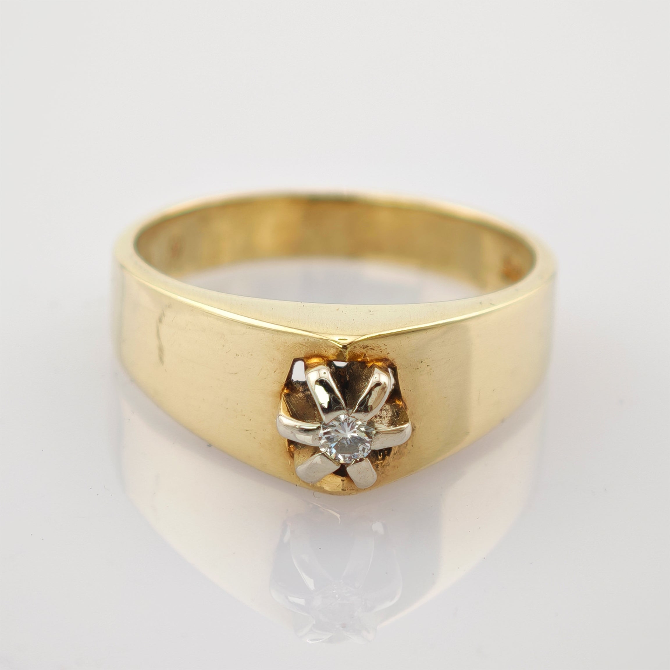 Goldener Ring mit funkelndem Diamanten in sechszackiger Fassung