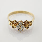 Goldener Ring mit feinem Design und sieben kleinen, runden weißen Steinen in Kreuzanordnung auf schmalem Band.