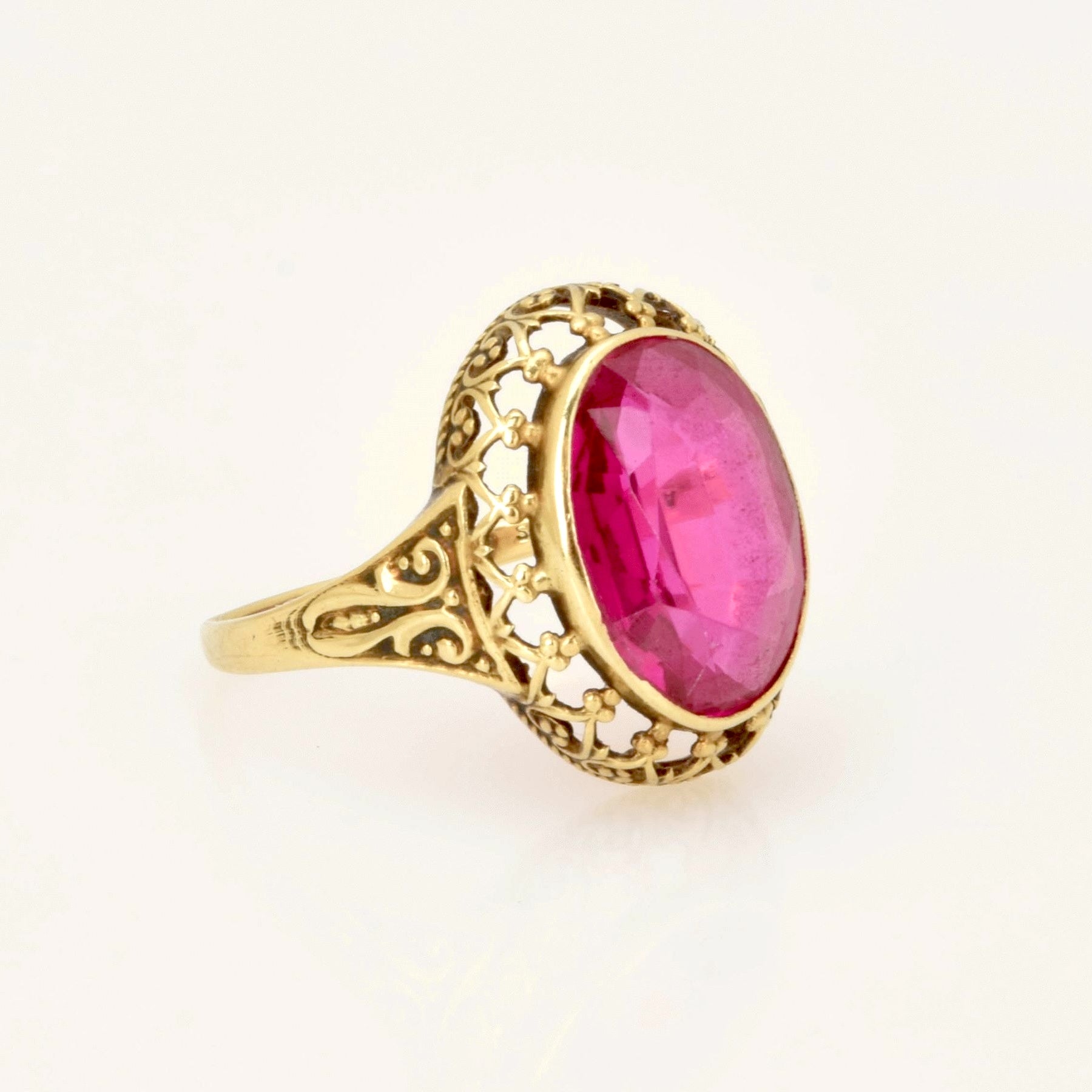Fein gearbeiteter goldener Ring mit ovalem, facettiertem rosa Edelstein