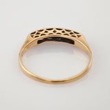 Goldener Ring mit filigranen Ausschnitten und elegantem Hohlraummuster auf hellem Hintergrund