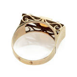 Nahaufnahme eines goldfarbenen Rings mit filigranem Muster und glattem Band