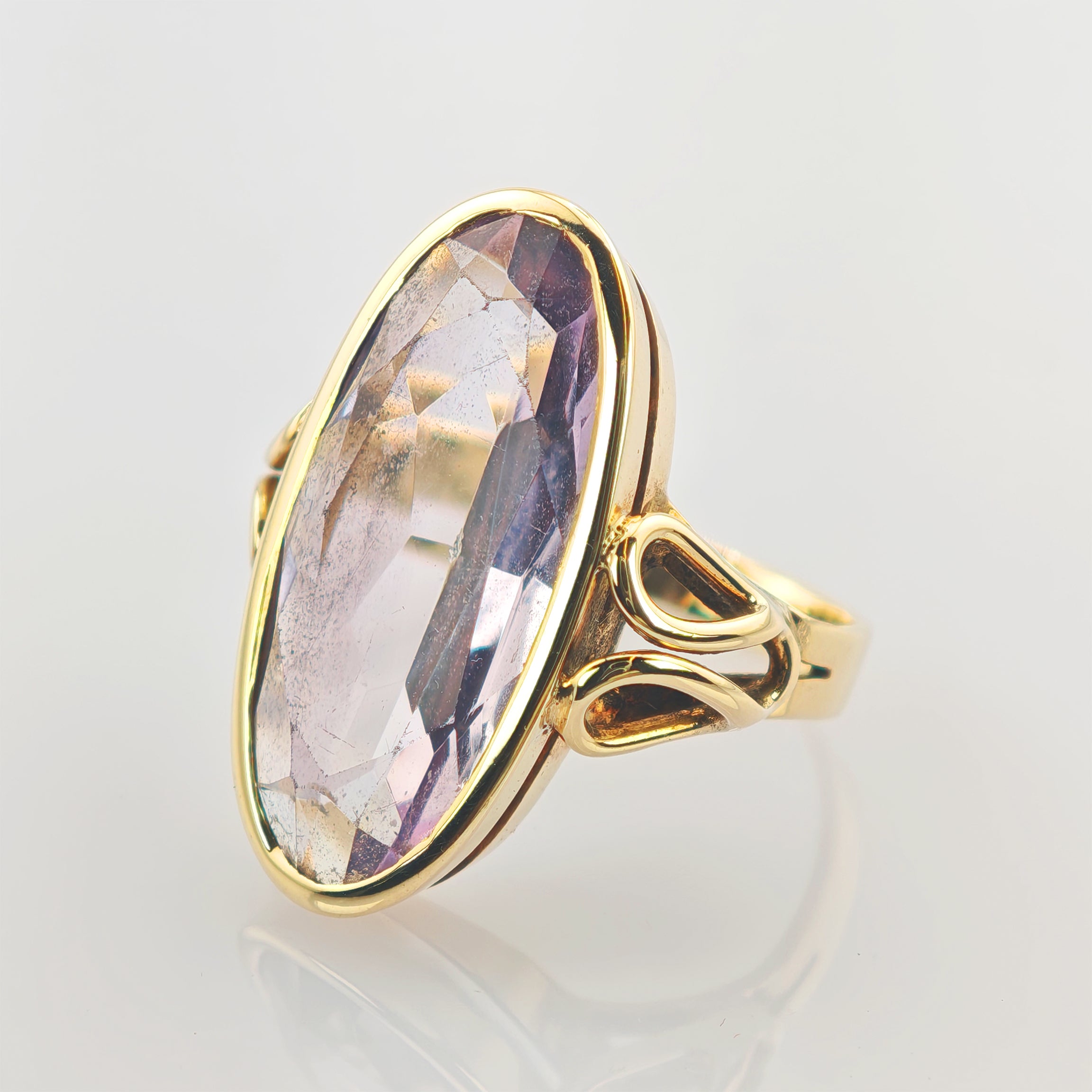 Goldener Ring mit ovalem, facettiertem Edelstein in hellem Violett und elegant gestalteter Ringschiene.