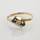 Goldener Ring mit rechteckigem Aufsatz und klaren sowie dunklen Edelsteinen