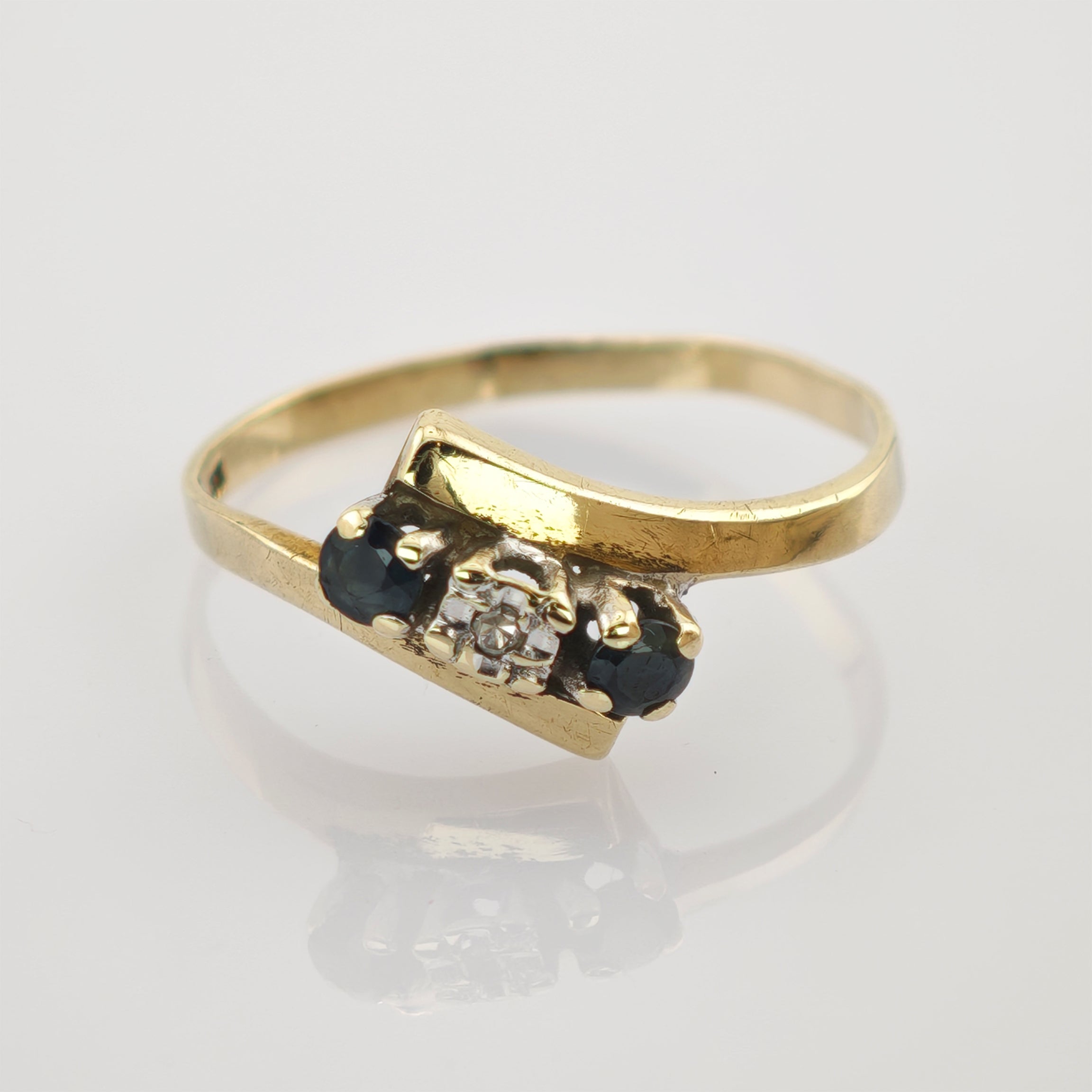 Goldener Ring mit rechteckigem Aufsatz und klaren sowie dunklen Edelsteinen