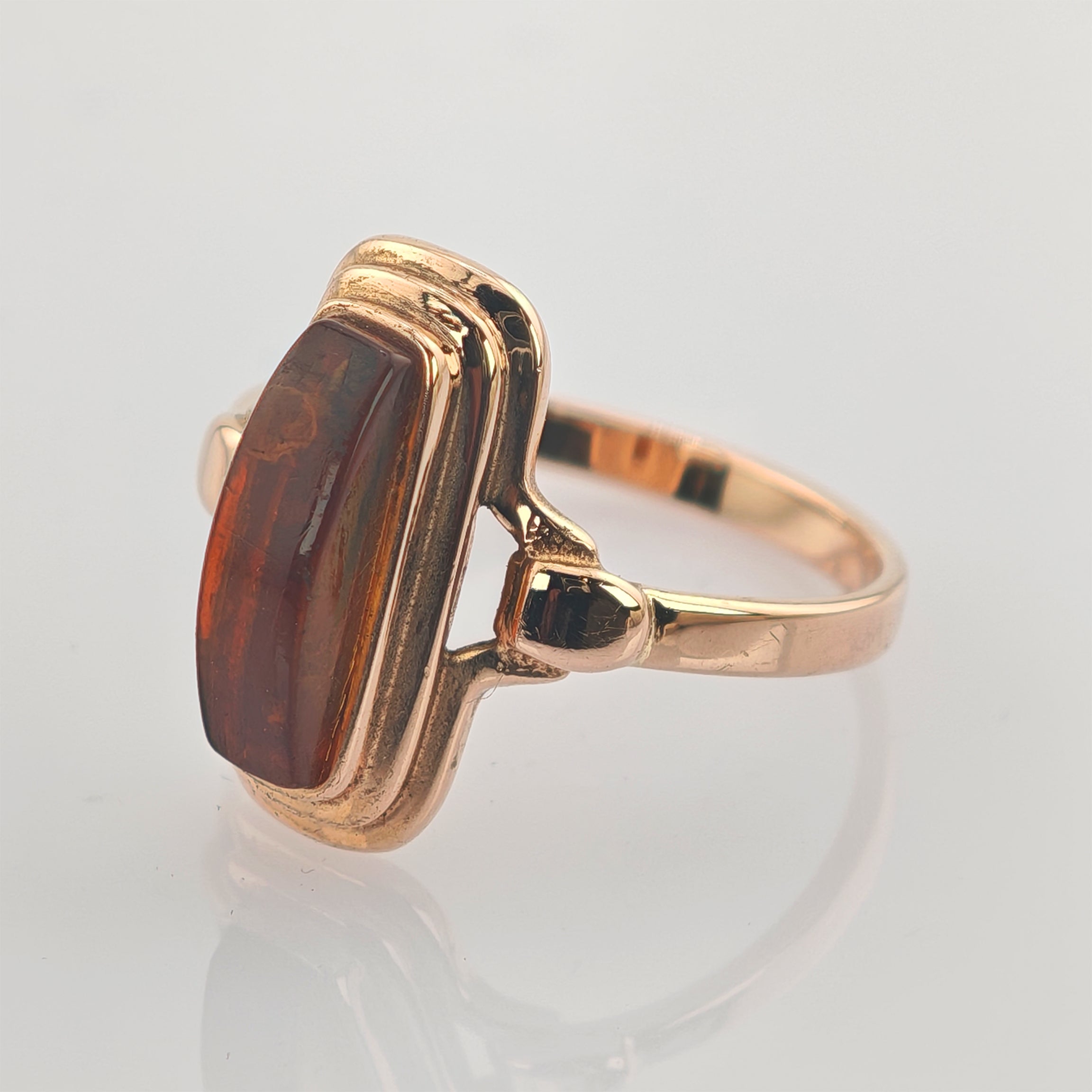 Goldener Ring mit rechteckigem braunem Edelstein und poliertem Band im Vintage-Design.