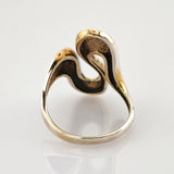 Goldener Ring mit elegantem wellenförmigem Design und gehämmerter Innenseite auf glänzend weißem Hintergrund.