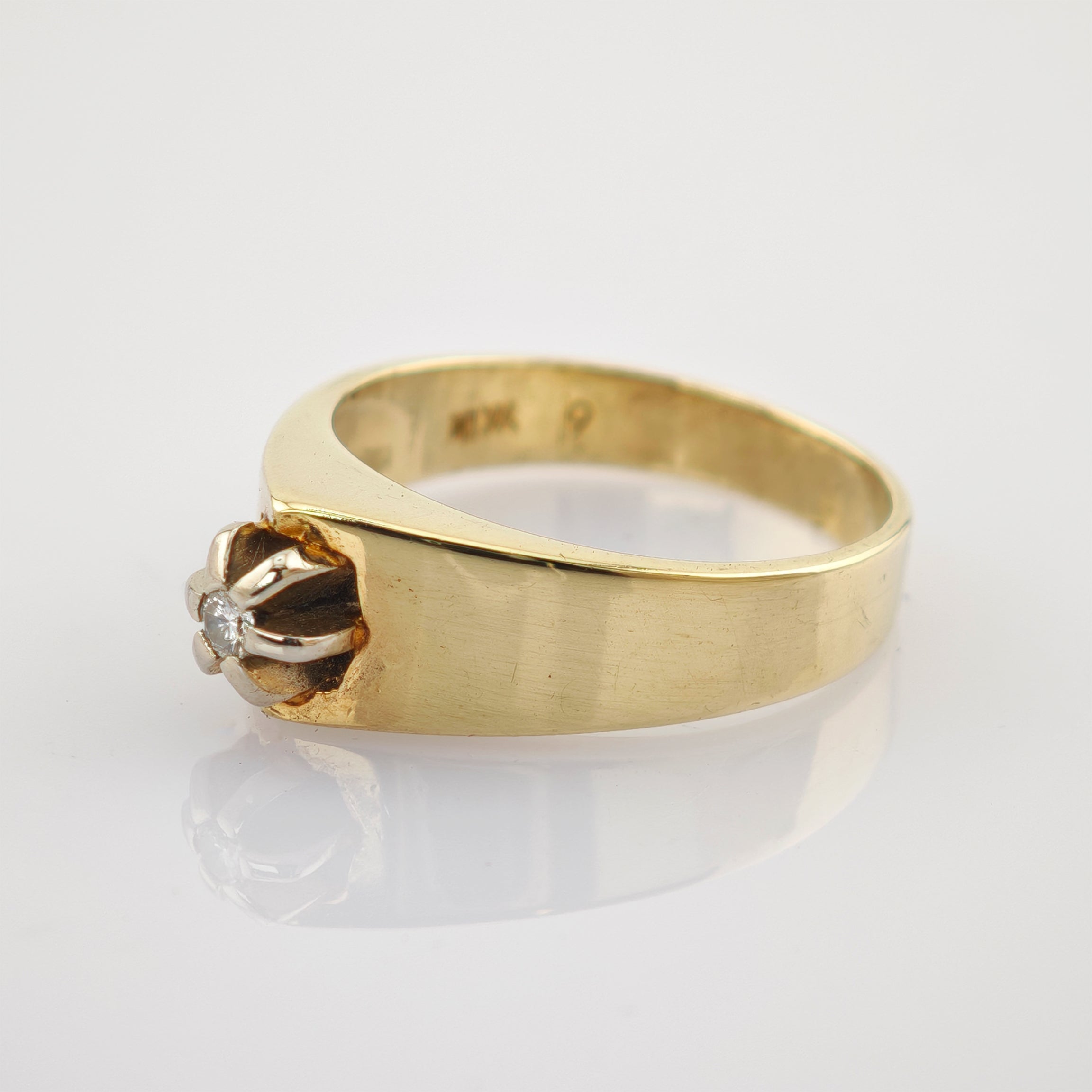 Goldring mit breitem flachem Band, blumenförmiger Fassung und kleinem Diamanten, 10K Punze.