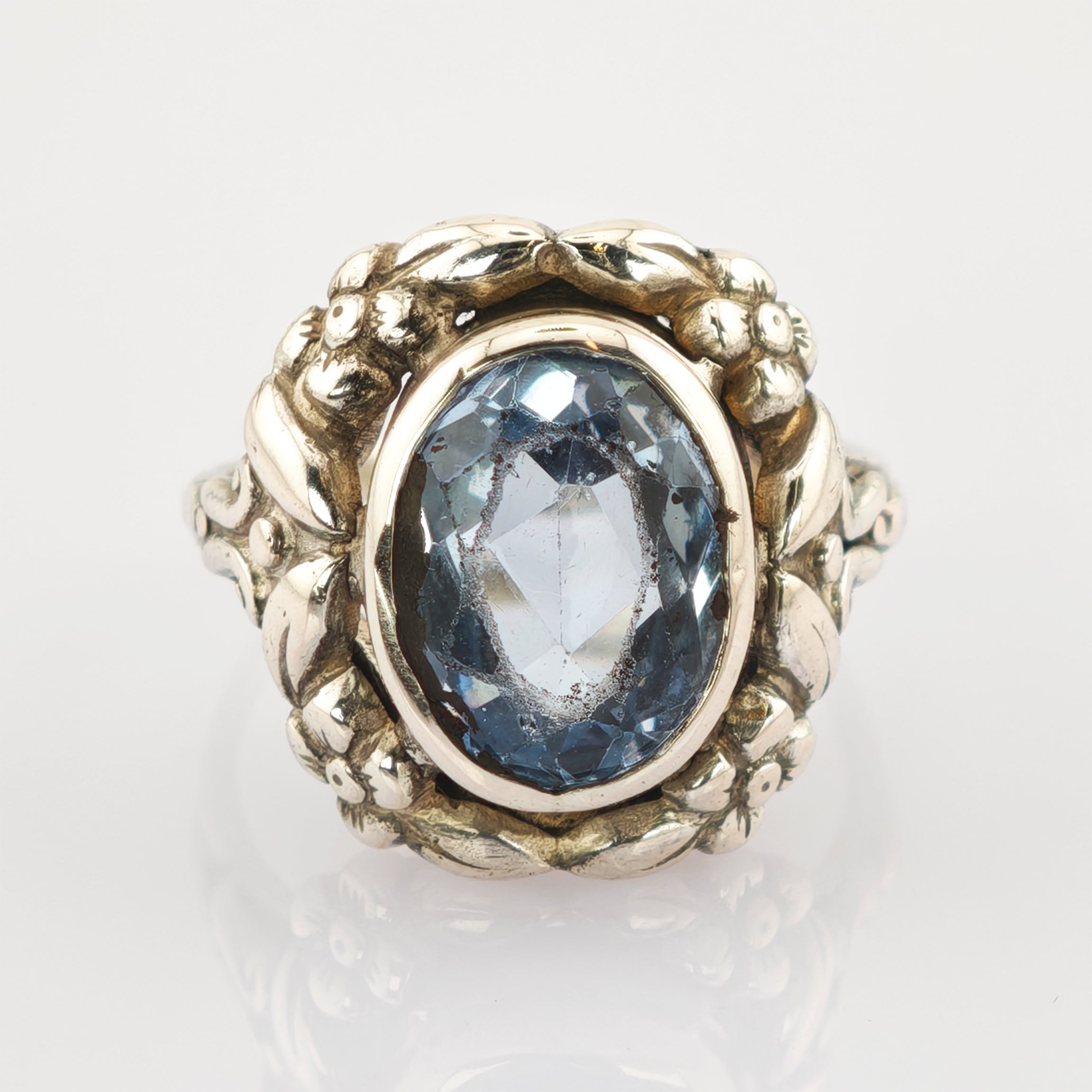 Goldring mit floralen Motiven und ovalem blauem Edelstein mit Einschlüssen