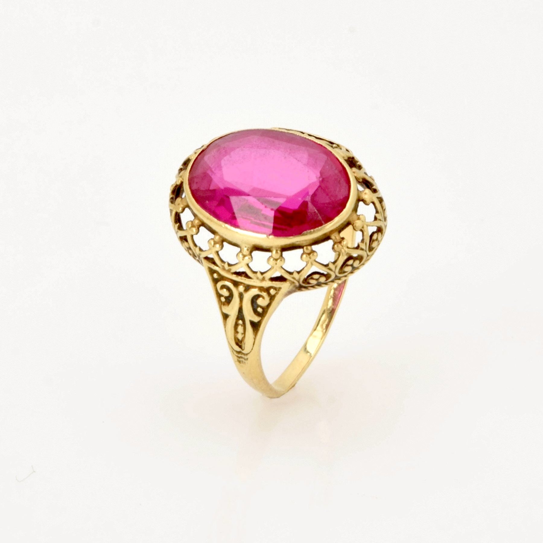 Goldring mit kunstvoll verziertem Band und großem oval facettiertem rosa Edelstein