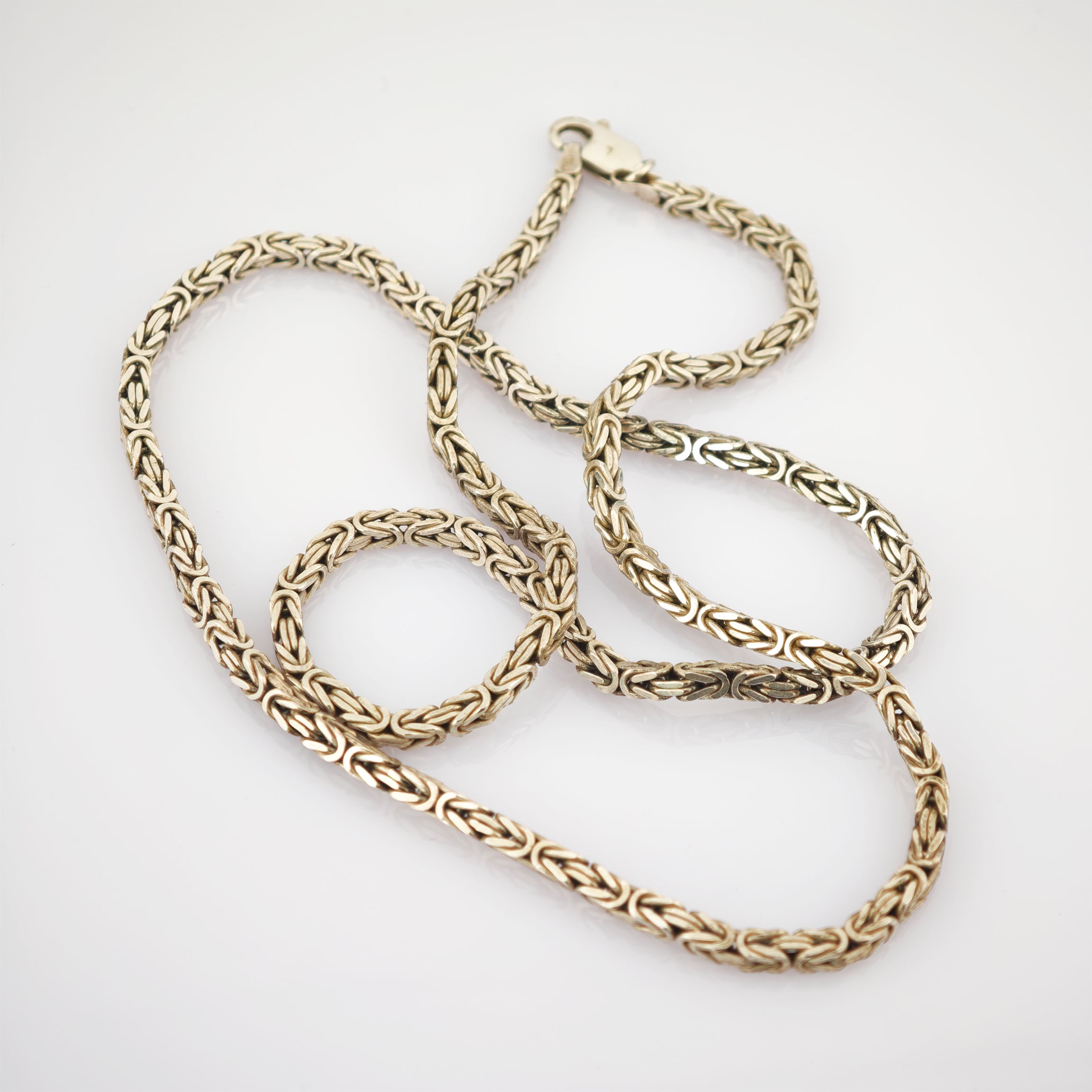 Silberne Königskette auf weißem Hintergrund