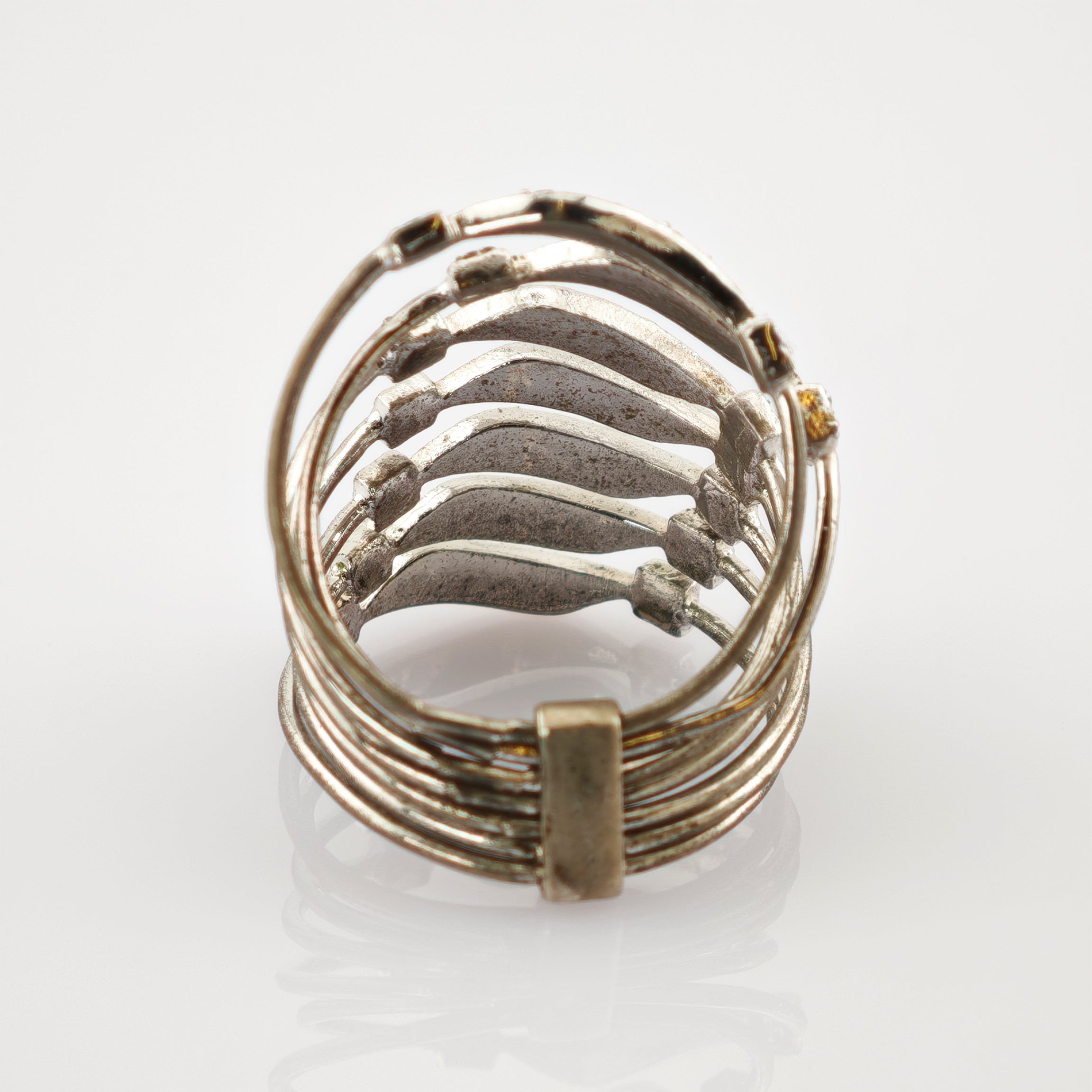 Metallring mit mehreren horizontalen Bändern und rechteckigem Verbindungsteil auf weißem Hintergrund