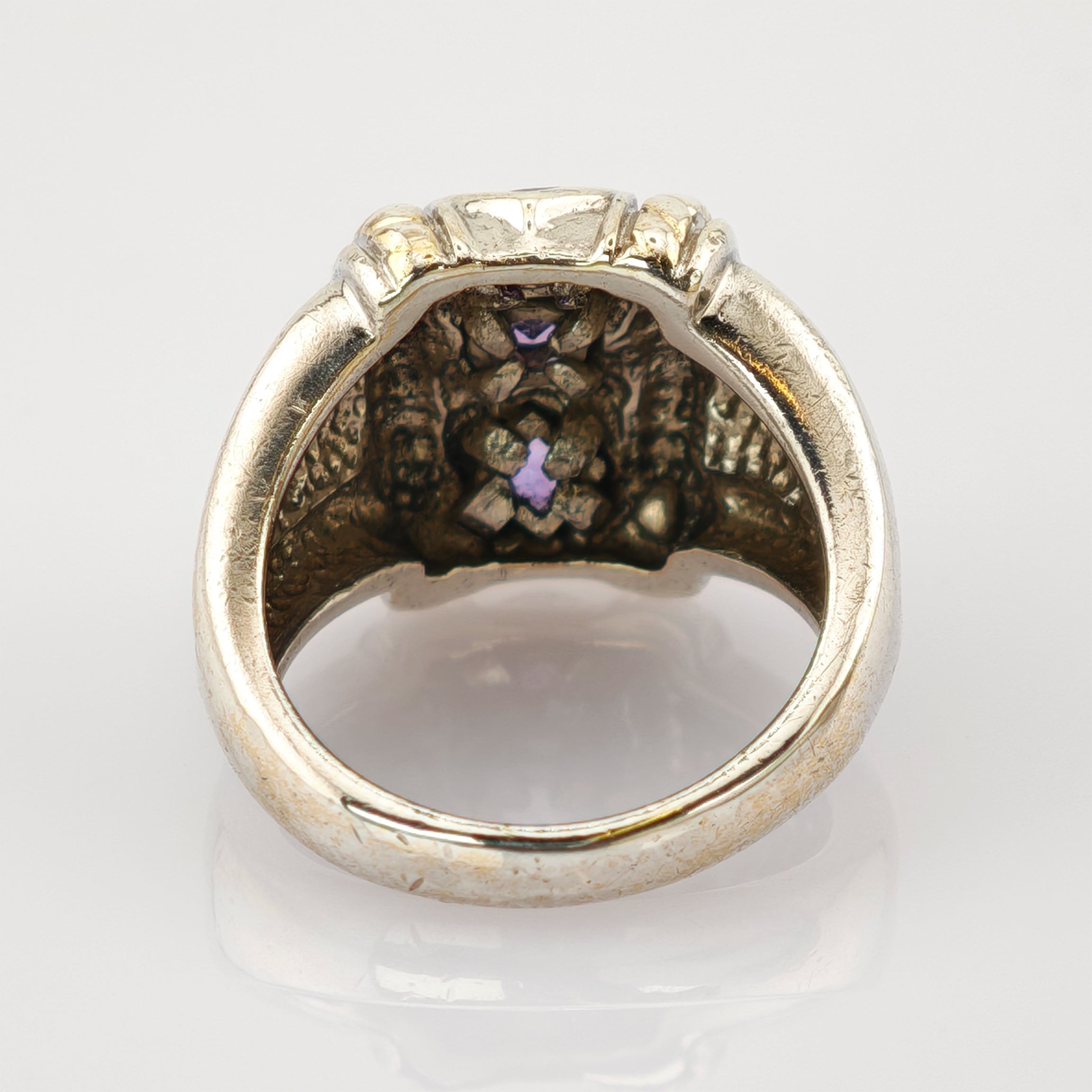 Metallring mit kunstvollem Innenrelief und lila Edelstein