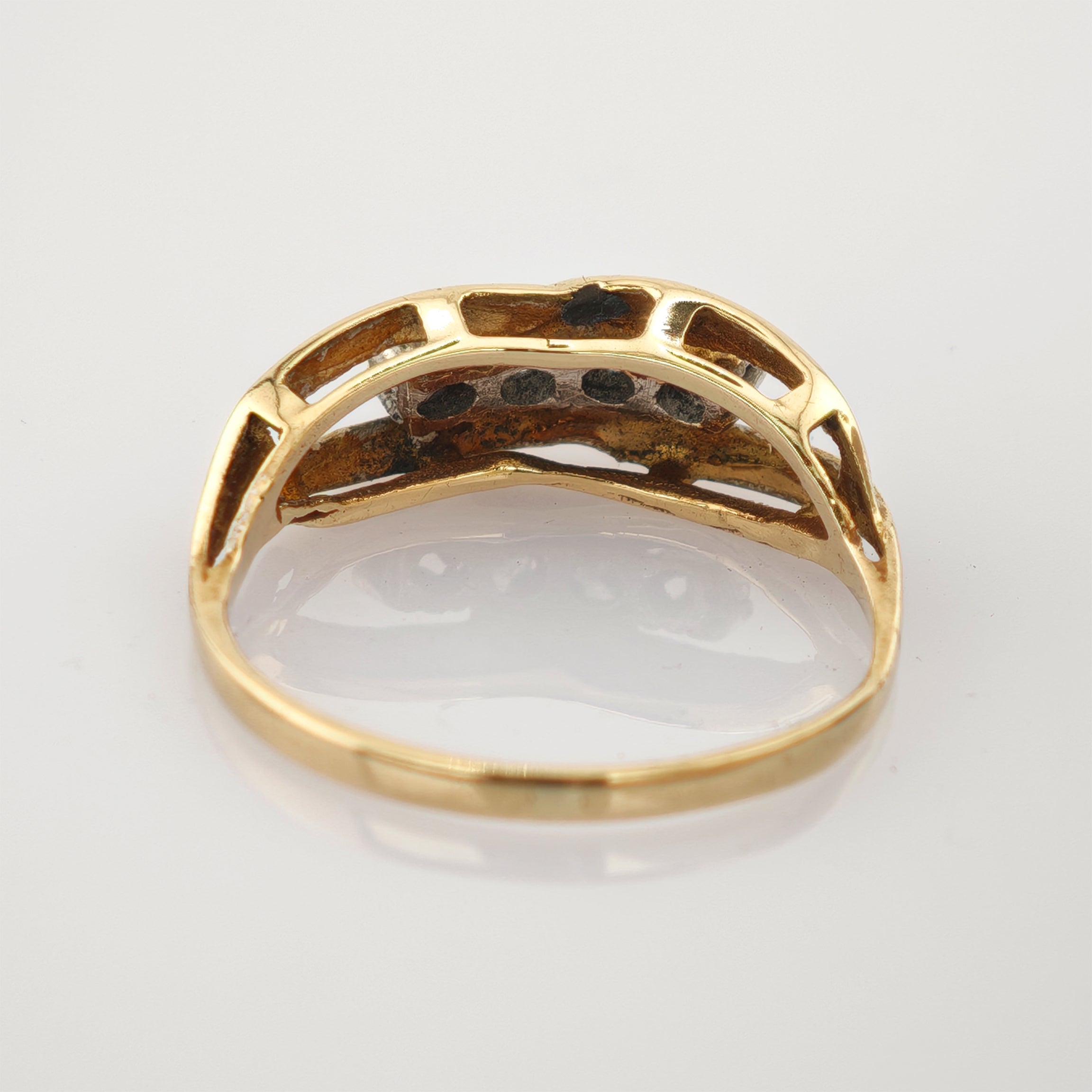 Nahaufnahme der Innenseite eines Goldrings mit offener Struktur und sichtbaren Metalltexturen.