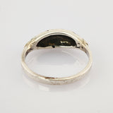 Nahaufnahme eines silbernen Rings mit glatter, leicht gebogener Oberfläche und dunkler Patina innen.