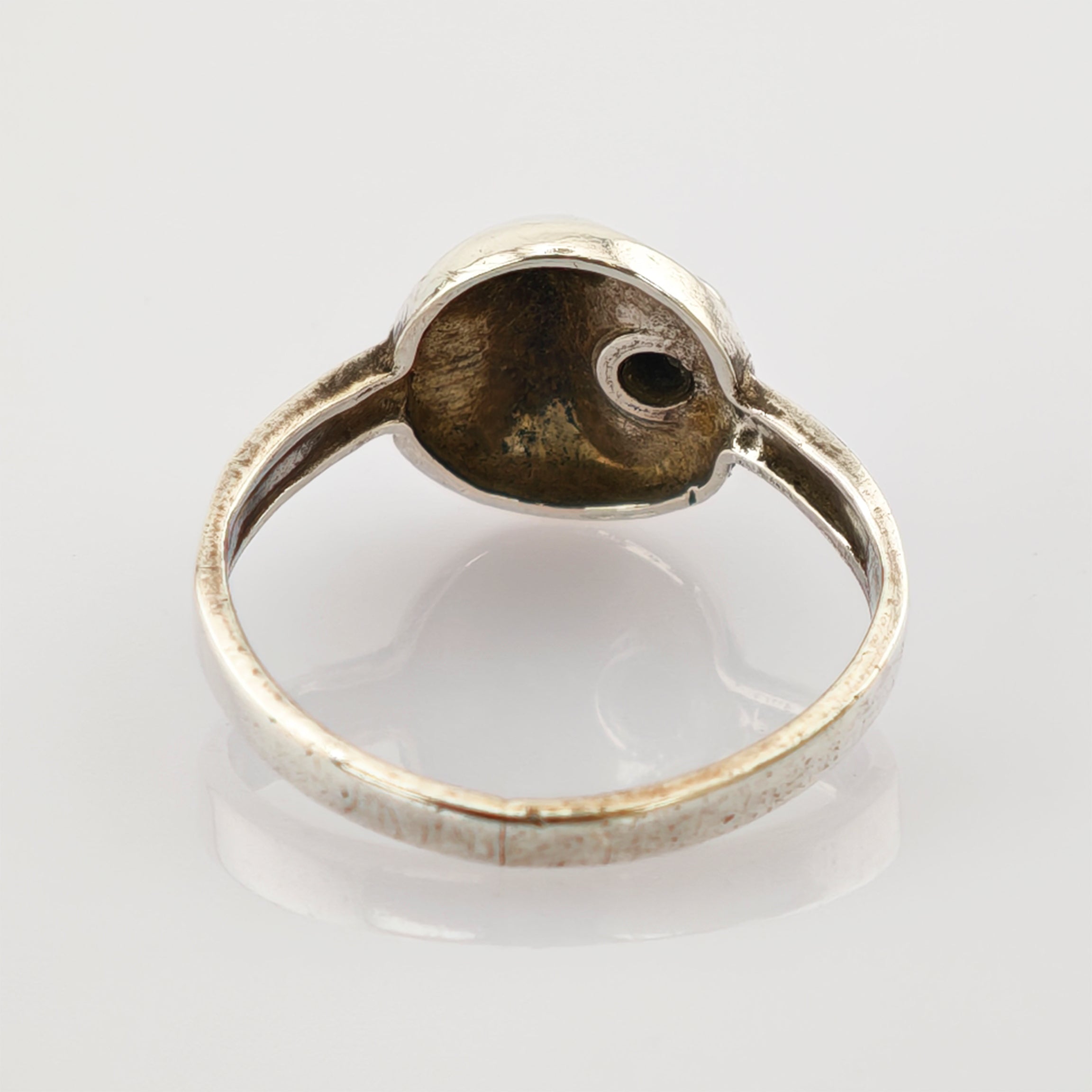 Detaillierte Nahaufnahme eines inneren Silberrings mit sichtbarer Patina und Textur.
