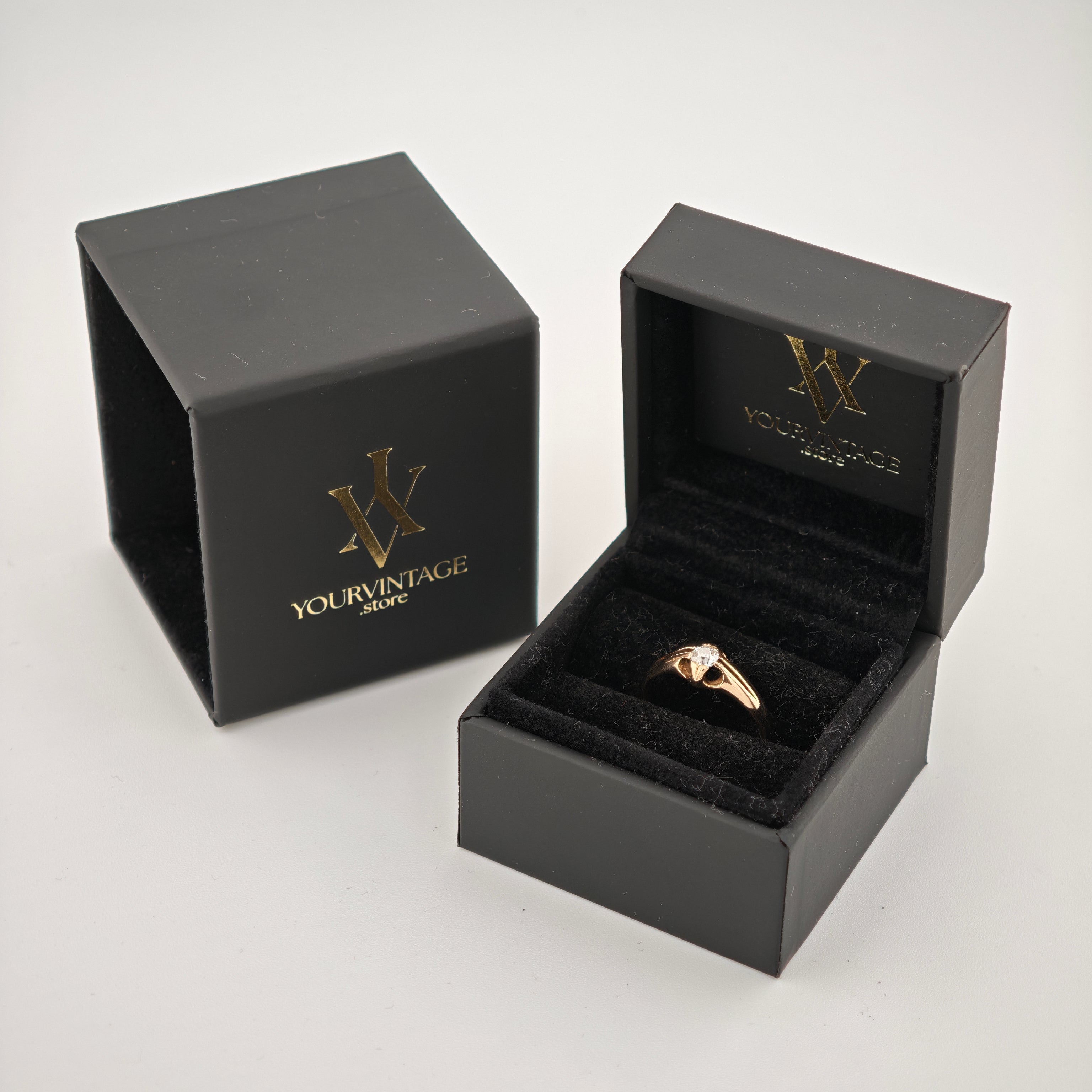 Offene schwarze Schmuckbox mit goldenem Ring und Diamant auf Samtkissen neben geschlossener Box von YOURVINTAGE.store