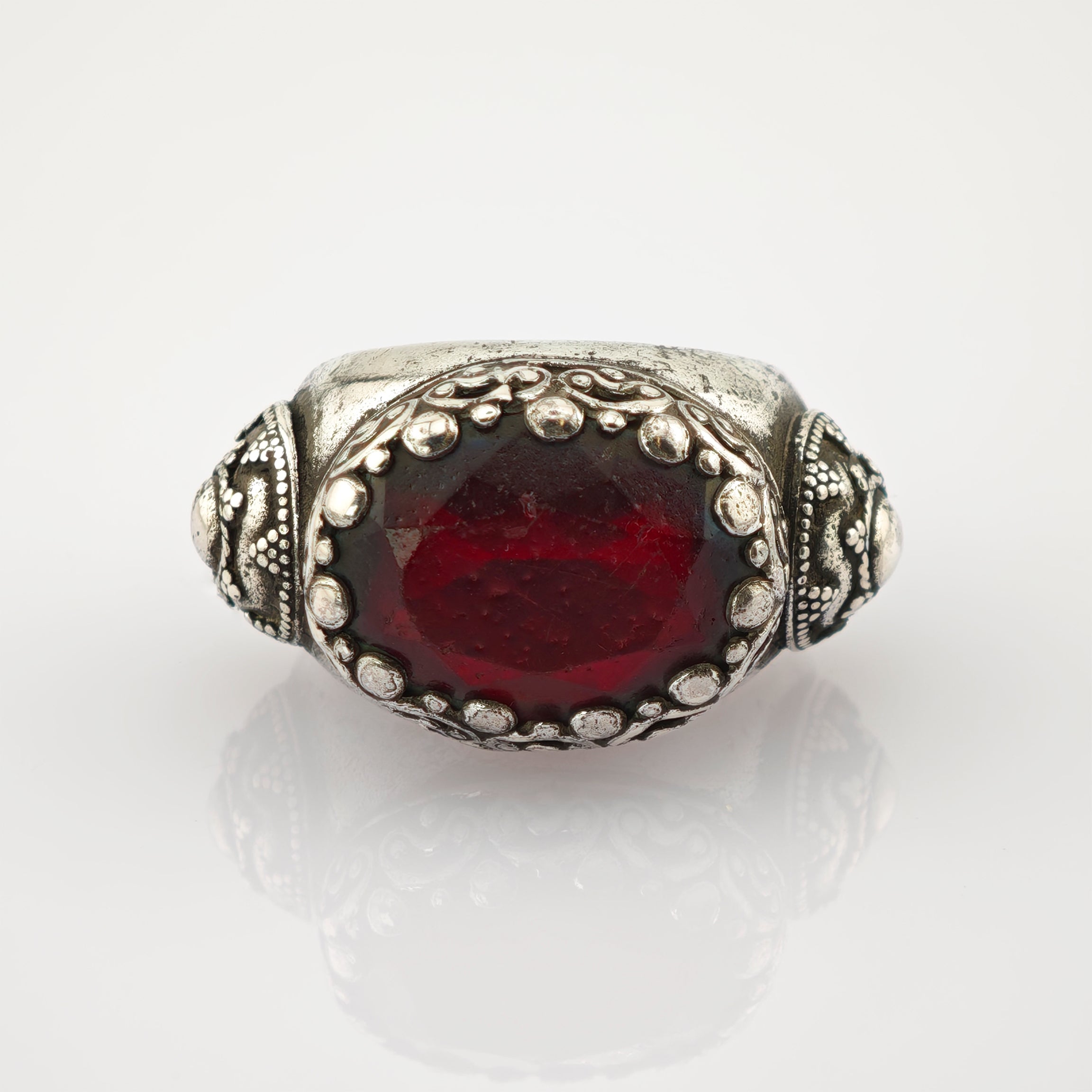 Ornater Silberring mit großem ovalem, tiefrotem Edelstein und filigranen Silberverzierungen.
