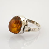 Polierter Silberring mit Bernstein auf weißem Hintergrund