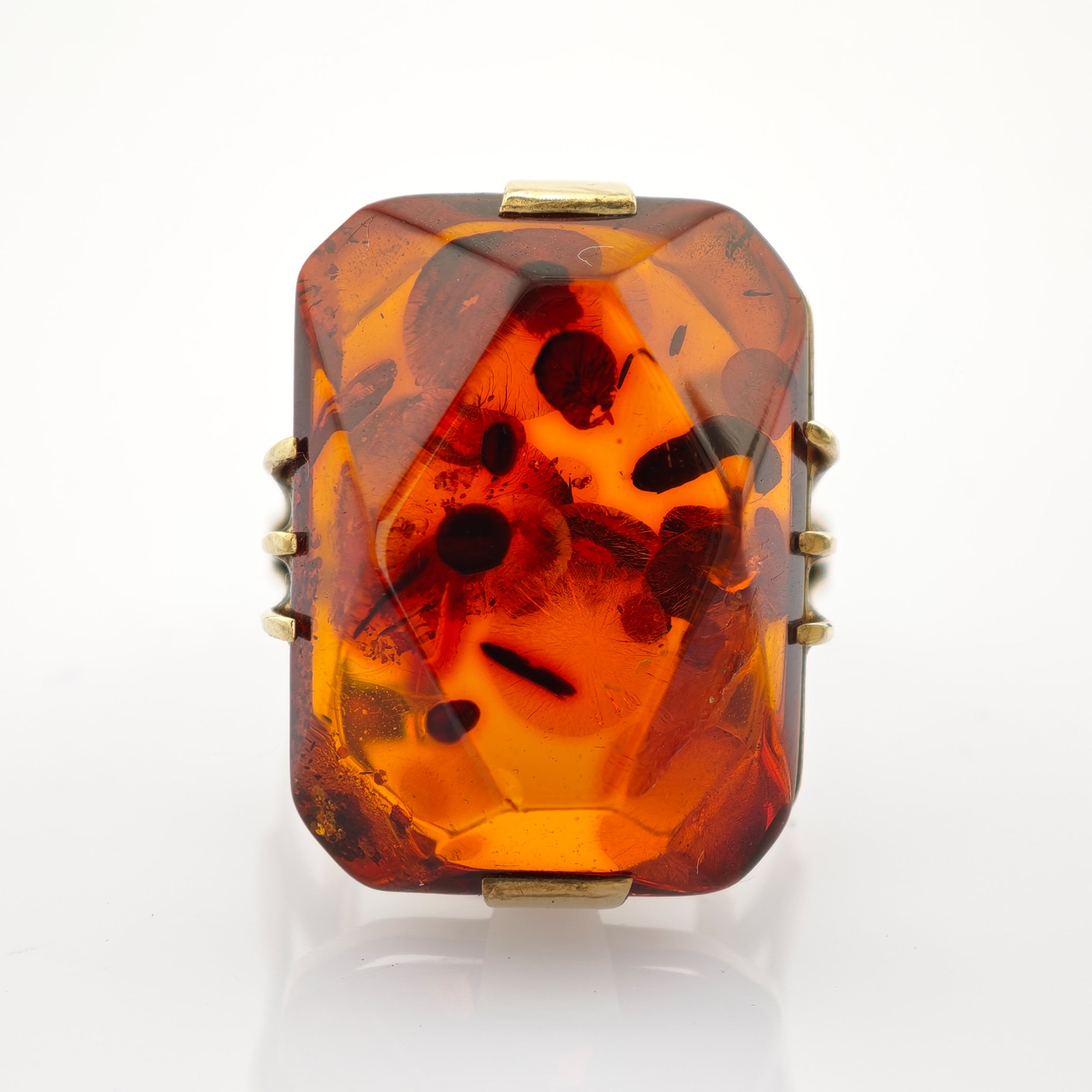 Rechteckiger Vintage-Bernstein mit organischen Einschlüssen, gold-orange, facettiert, in einfachem Metallrahmen.