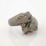 Ring mit zwei Drachenköpfen, funkelnden Steinen und grünen Edelsteinaugen, silberne Akzente