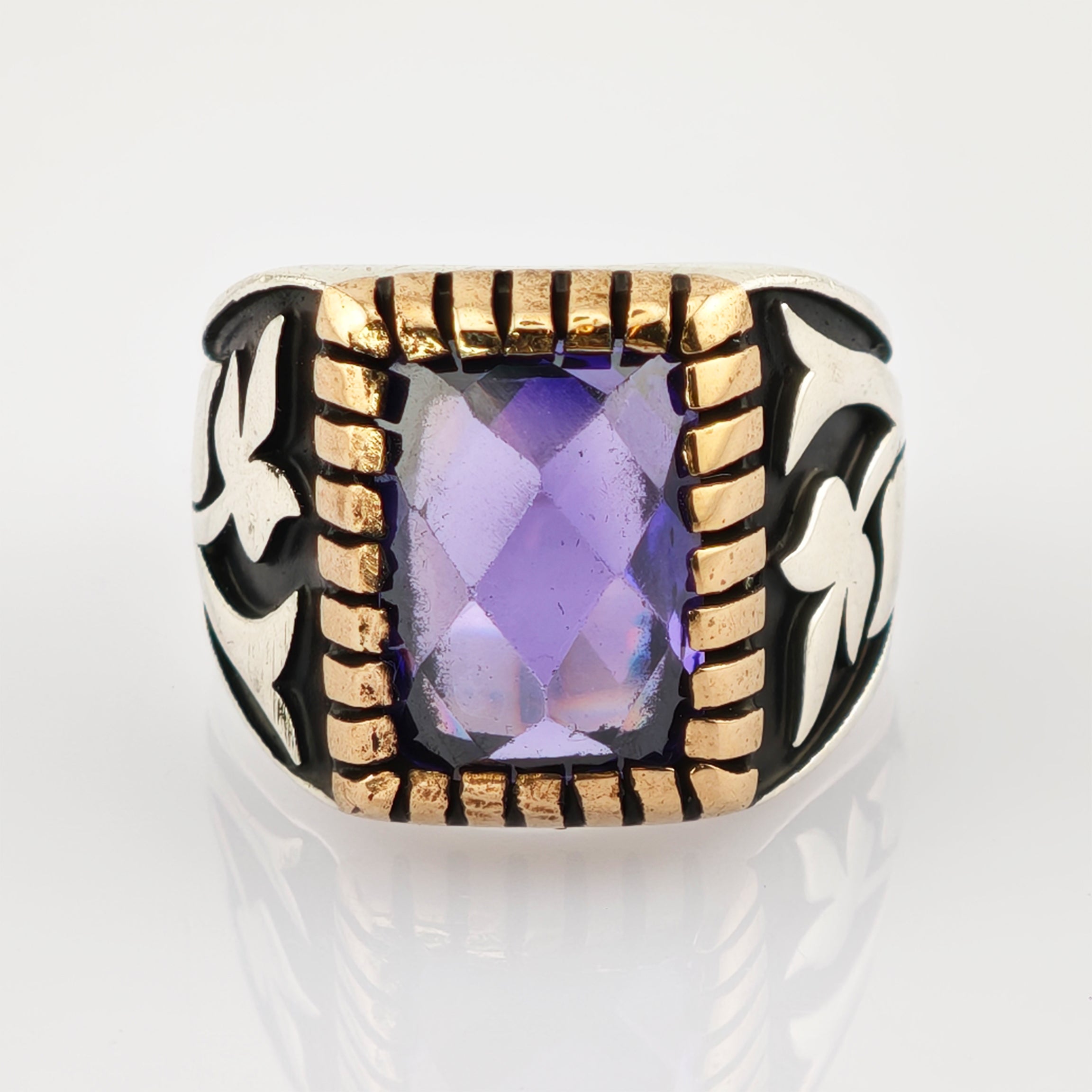 Ring mit facettiertem rechteckigem violettem Edelstein und silbernem Band mit schwarzem Email