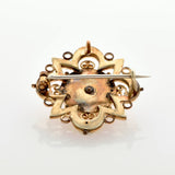 Rückseite einer goldenen Vintage-Brosche mit verziertem Design und Nadelverschluss