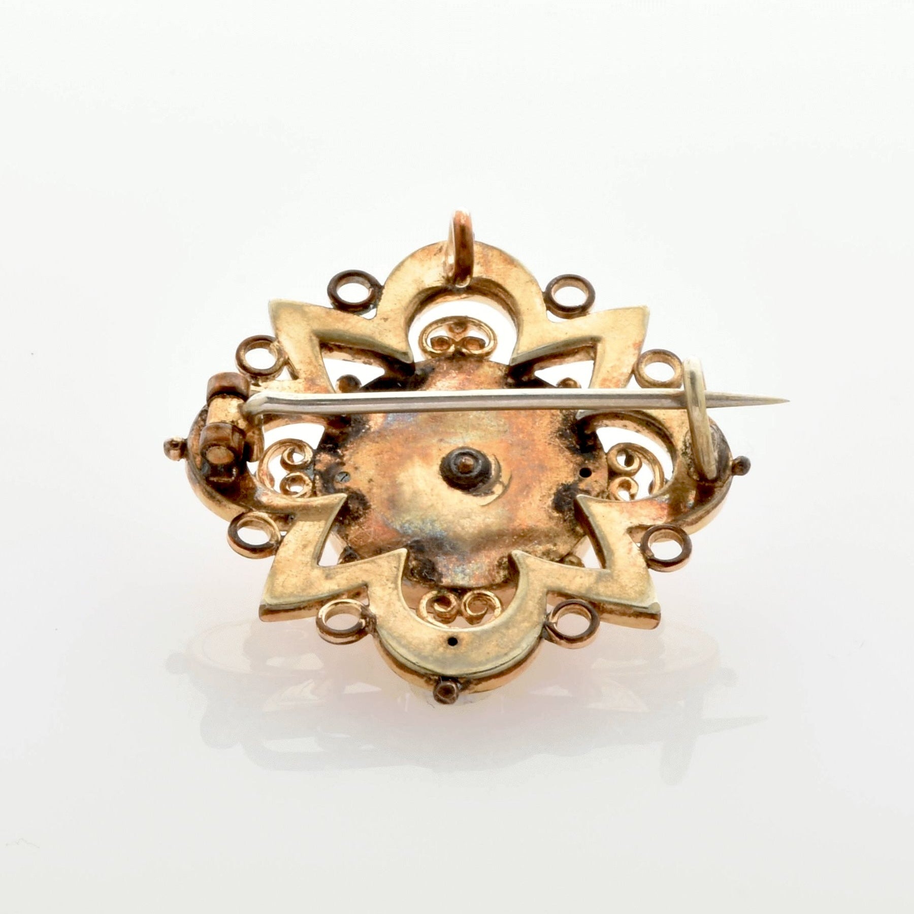 Rückseite einer goldenen Vintage-Brosche mit verziertem Design und Nadelverschluss