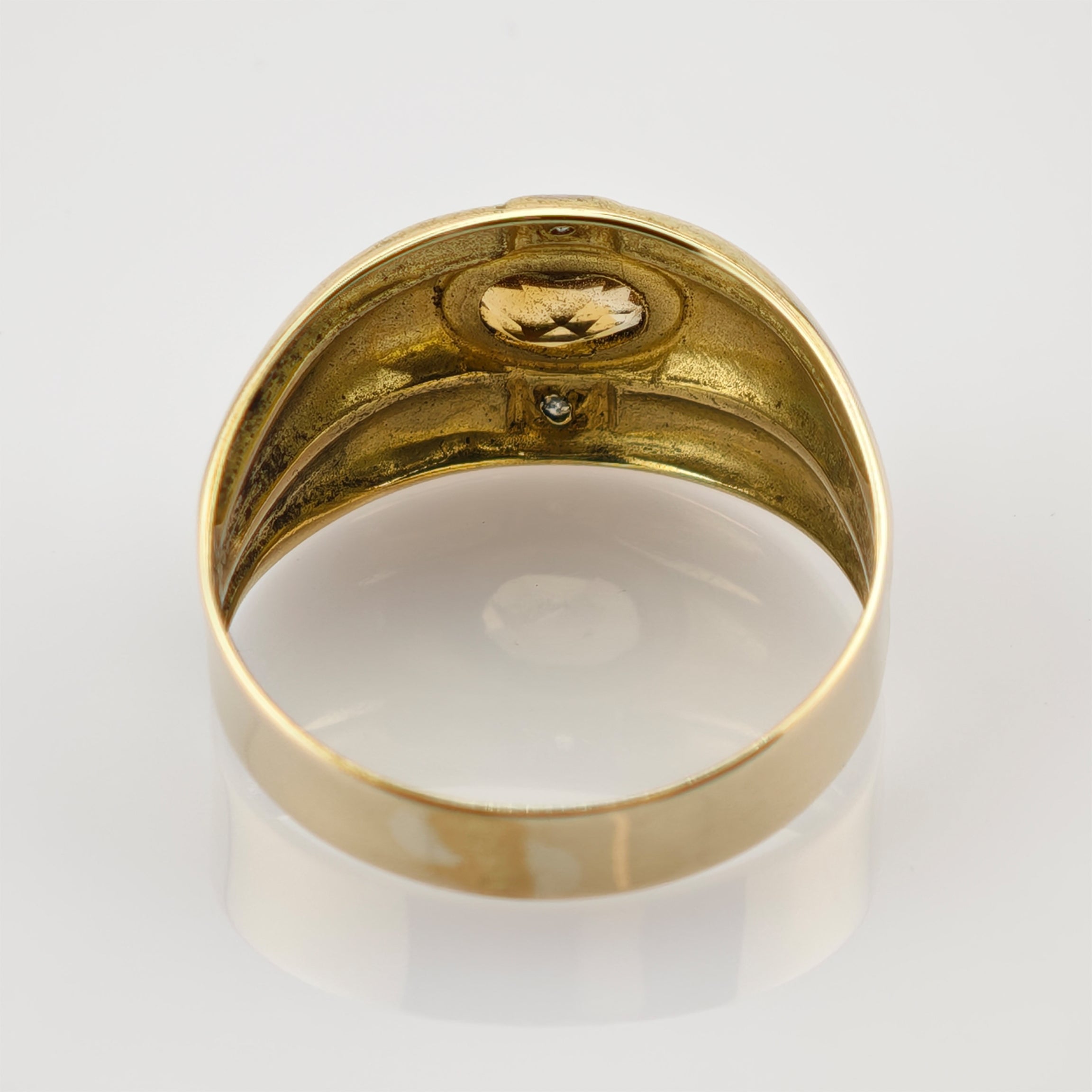 Goldener Ring mit ovalem gelbem Edelstein und zwei klaren Steinen auf weißem Hintergrund, Rückseite.