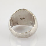 Reflektierender Metallring mit 925er-Silberpunze, abgenutzte Oberfläche und Kratzer vor hellgrauem Hintergrund