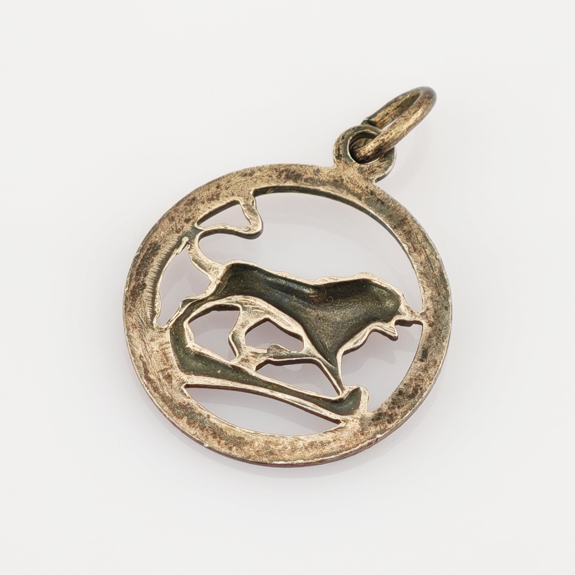 Runder Metallanhänger mit offenem Design und stilisierter Darstellung eines laufenden Hundes.