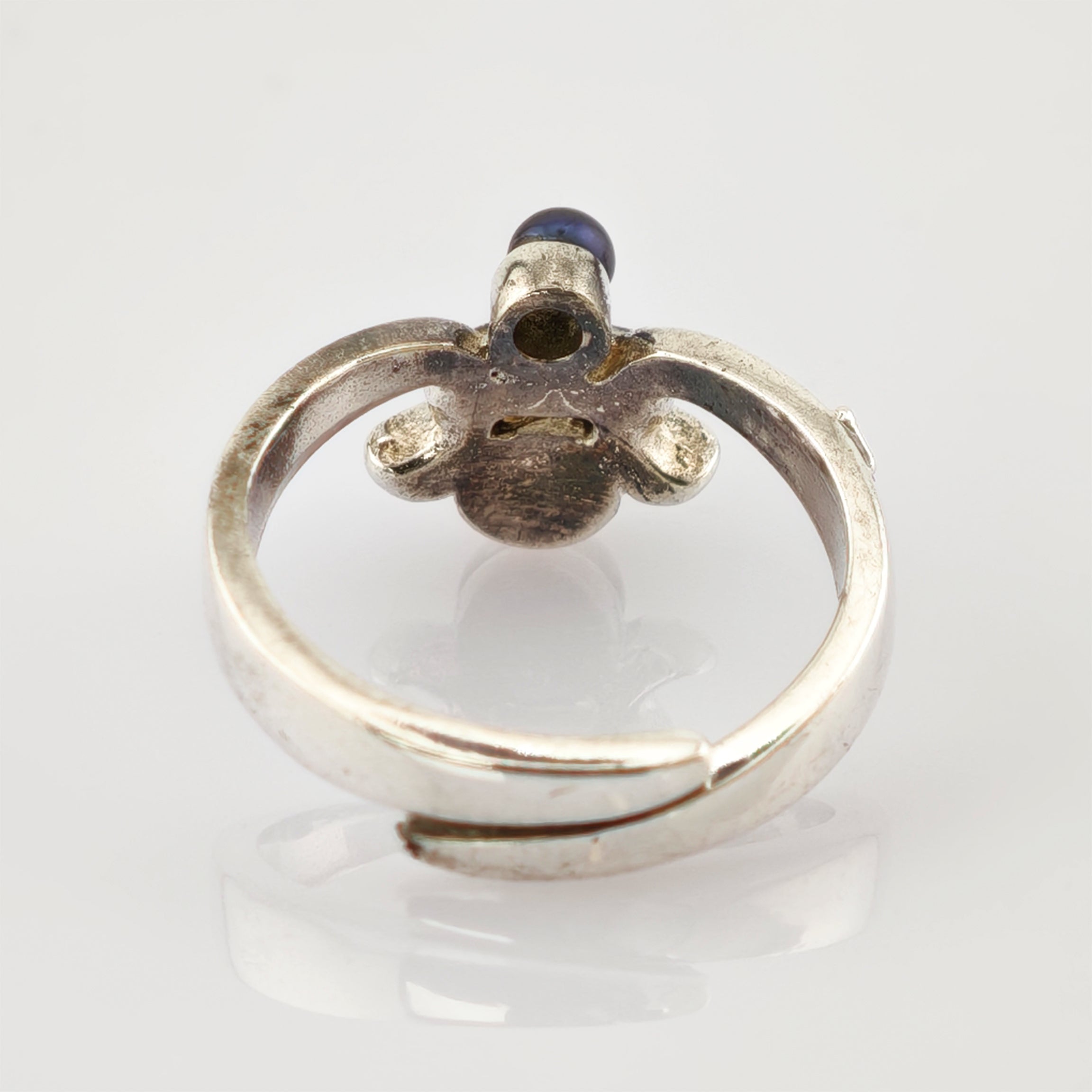 Runder Silberring mit kleinem dunklem Edelstein und sichtbarem Ringband von innen.